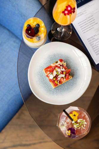 a plate with a slice of pizza on a glass table at Courtyard by Marriott Paris Porte de Versailles in Issy-les-Moulineaux