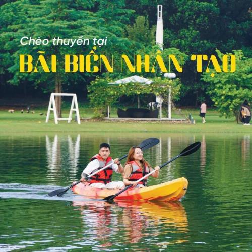 a man and a woman in a kayak on a lake at Green Villa 5 phòng ngủ ở Flamingo Đại Lải Resort in Phúc Yên