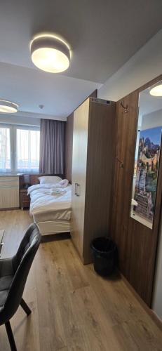 a bedroom with a bed and a chair in a room at Metropolis Apartamenty Centrum in Kalisz
