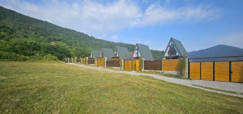a row of houses in a field next to a hill at Cafe Del Montana in İsmayıllı