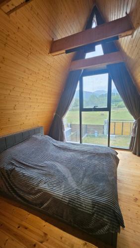 a bed in a room with a large window at Cafe Del Montana in İsmayıllı