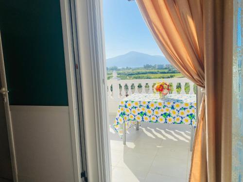 a table with a vase of flowers on a balcony at Donald Hotel in Vlorë
