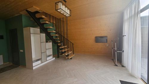 a room with a spiral staircase and a television at Cafe Del Montana in İsmayıllı