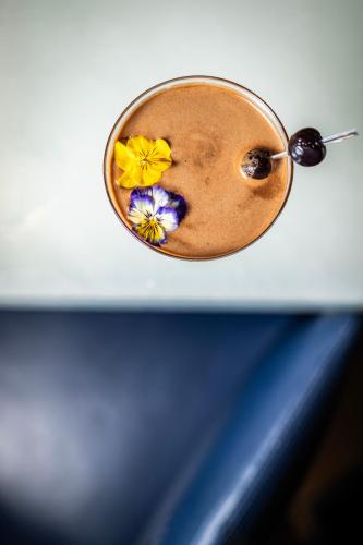 a cup with flowers on top of a table at Courtyard by Marriott Paris Porte de Versailles in Issy-les-Moulineaux