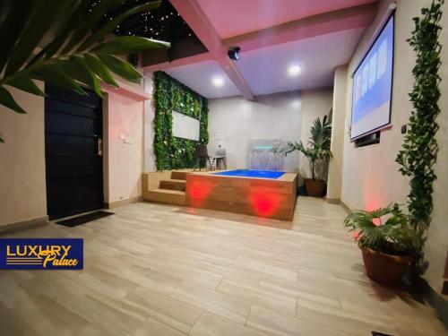 a lobby with a large room with a tv and plants at Luxury Palace 