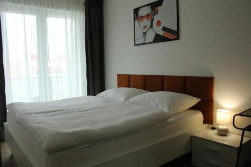 a bedroom with a white bed with a picture on the wall at Hotel Plzeň in Plzeň