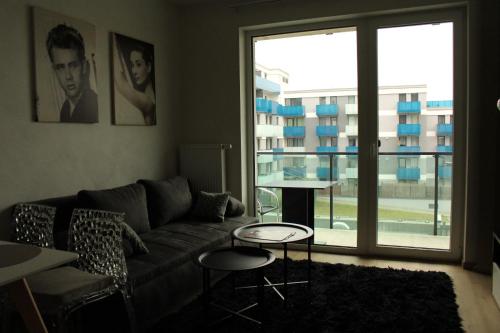 a living room with a couch and a large window at Hotel Plzeň in Plzeň