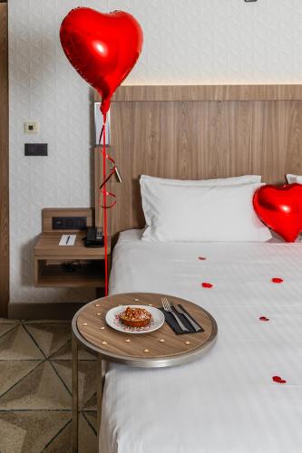 a heart balloon and a plate of food on a bed at Courtyard by Marriott Paris Porte de Versailles in Issy-les-Moulineaux