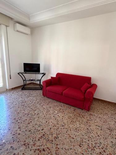 a living room with a red couch and a table at La CASA DEL SOLE in Paceco