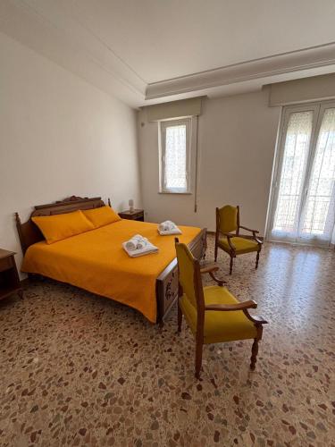 a bedroom with a large bed and two chairs at La CASA DEL SOLE in Paceco