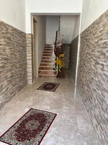 a hallway with a staircase with rugs and a brick wall at La CASA DEL SOLE in Paceco