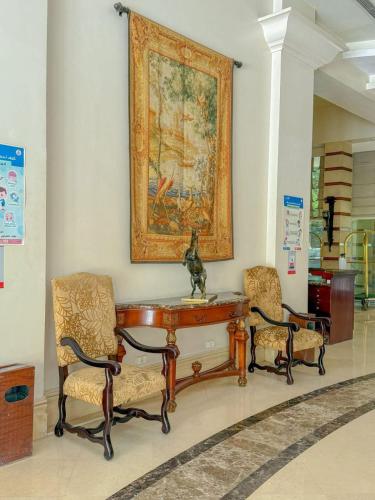 a table and two chairs and a painting on the wall at Amarante Pyramids Hotel in Cairo