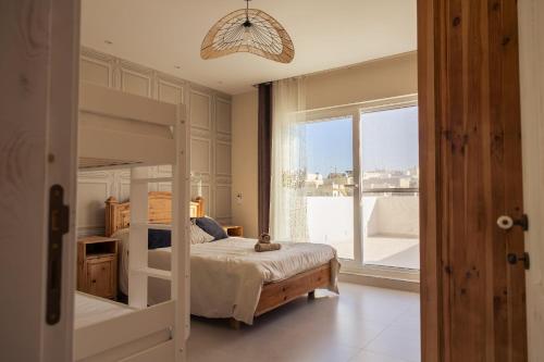 a bedroom with a bunk bed and a large window at Villa to rent in Gozo- Iż-Żerriegħa tal-Mustarda in Santu Pietru