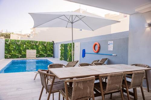 a dining room with a table and chairs and a pool at Villa to rent in Gozo- Iż-Żerriegħa tal-Mustarda in Santu Pietru