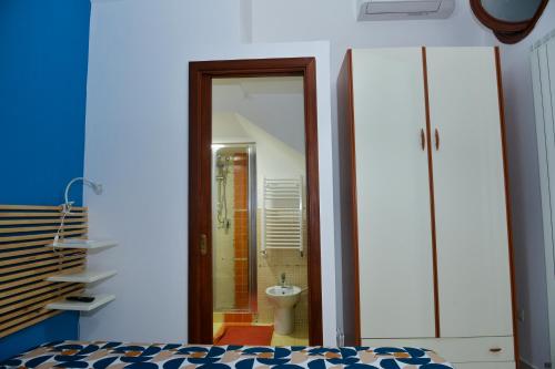 Un dormitorio con un baño con inodoro y espejo. en Casa Ines, en Sant'Agnello