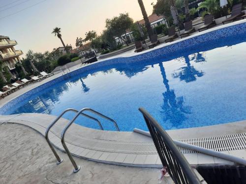 a large blue swimming pool with chairs and avationliest at APARTMAN NIKA BUDVA-PRZNO in Budva