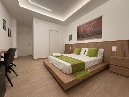 a bedroom with a large bed and a desk at Domus Matronae in Castellammare di Stabia