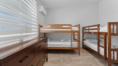 a room with bunk beds and a desk and a window at Near El Combate Beach Free Parking Bbq in Cabo Rojo