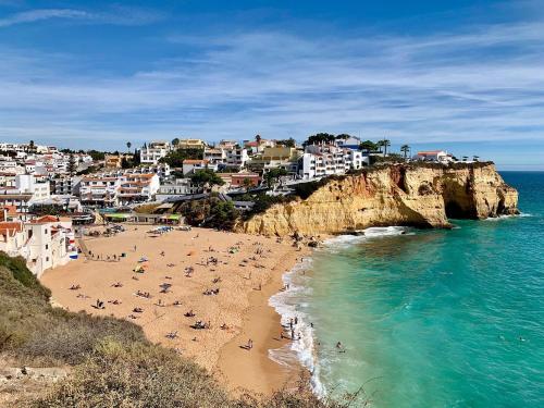 a group of people on a beach near the ocean at Golf - Vale Da Pinta T2 com Piscina, Wi-Fi e Ar Condicionado in Carvoeiro