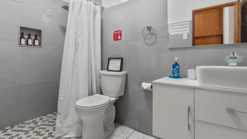 a white bathroom with a toilet and a sink at Near El Combate Beach Free Parking Bbq in Cabo Rojo
