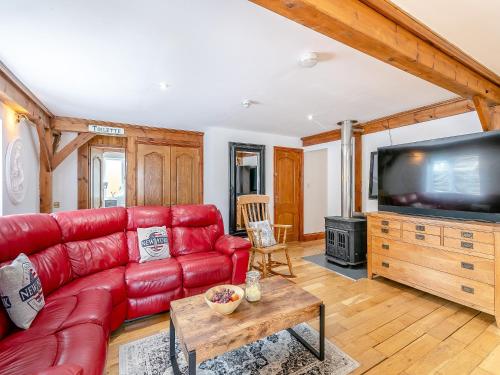 a living room with a red couch and a flat screen tv at The Lodge in Gloucester