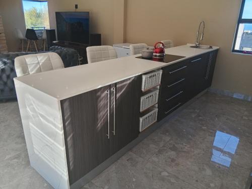 a kitchen island with a white counter top at Lovemoreheights Inn in Gqeberha