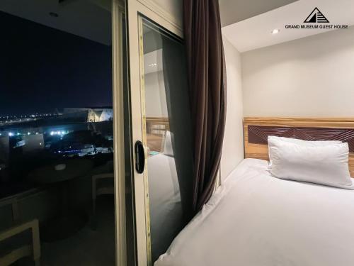 a bedroom with a bed with a view of a city at grand museum view hotel in Cairo