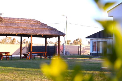 a pavilion with a table and benches in a yard at Cabañas Willy Azul con pileta climatizada y parque en Mendoza in Las Compuertas