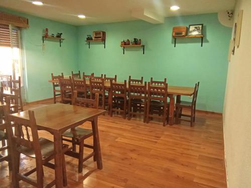 una sala da pranzo con tavoli e sedie in legno di Hostal casa Hinojosa a Hinojosa de Duero