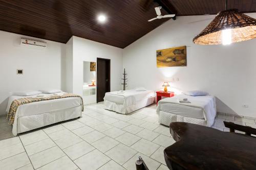 a room with two beds and a couch in it at Pousada Camury in Garuva