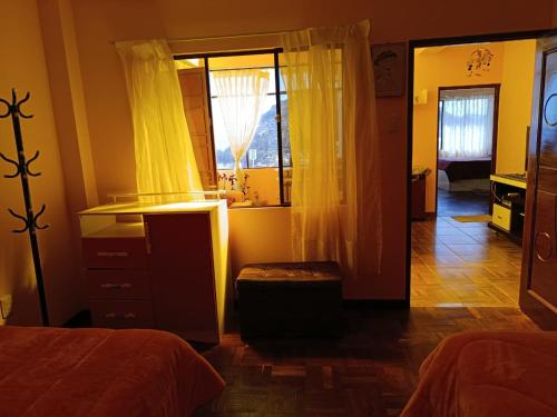 a bedroom with a window and a dresser and a mirror at Villa Bella Doña Leo in Copacabana