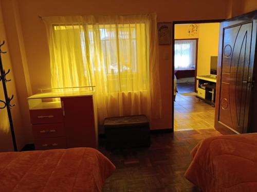a bedroom with two beds and a dresser and a mirror at Villa Bella Doña Leo in Copacabana