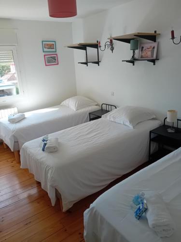 three beds in a room with white walls and wooden floors at circuit expo zenith in Le Mans
