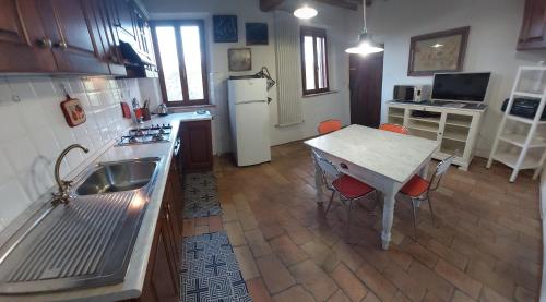 eine Küche mit einem Tisch und einem weißen Kühlschrank in der Unterkunft Boutique Apartment Podere Merlo in Parma