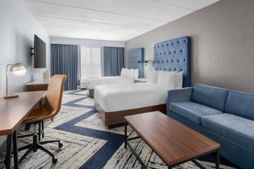 a hotel room with a bed and a couch at Four Points by Sheraton College Park Atlanta Airport in Atlanta
