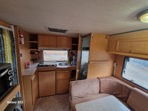 einen Wohnwagen mit Sofa und Küche darin in der Unterkunft Camping Principata 
