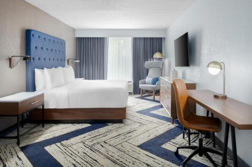 a hotel room with a bed and a desk at Four Points by Sheraton College Park Atlanta Airport in Atlanta