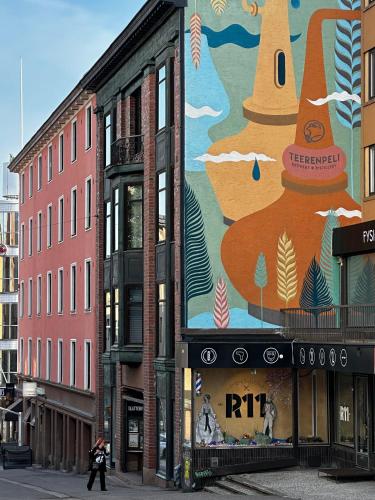 a large mural on the side of a building at Uniikki keskustahuoneisto pihaterassilla, bm Garden Apartments no2, free parking in Lahti
