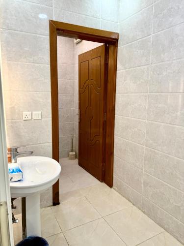 a bathroom with a sink and a wooden door at شاليهات زارا 2 in Taif