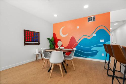 a dining room with a table and chairs and a painting at SLC Townhome 2BR Mountain Views Garage in Salt Lake City