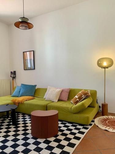 a living room with a green couch in a room at Acquasparta Piazza in Acquasparta