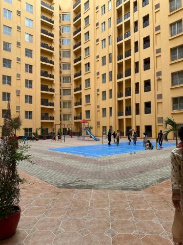 a group of people in a courtyard with tall buildings at AC - Studio Apartment in Karachi