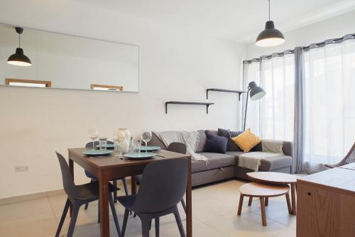 a living room with a table and a couch at Belleville by Shmoo in San Ġwann