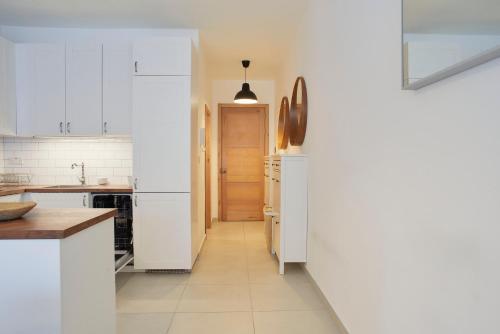 a kitchen with white cabinets and a refrigerator at Belleville by Shmoo in San Ġwann