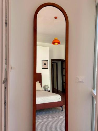 a mirror with a wooden frame in a bedroom at Acquasparta Piazza in Acquasparta