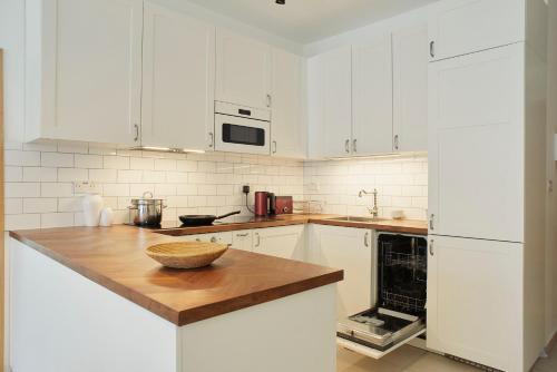 a kitchen with white cabinets and a wooden counter top at Belleville by Shmoo in San Ġwann