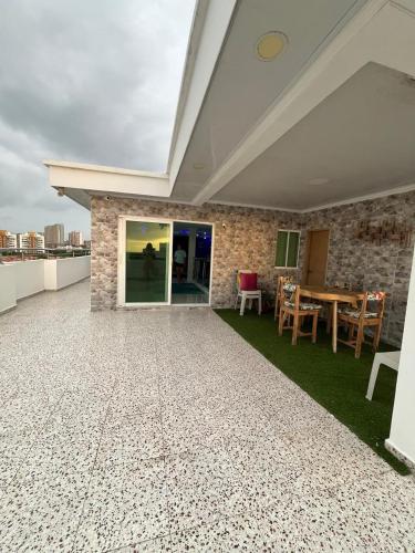 a patio with a table and chairs on a roof at Lindo Apartamento suite country club villas in Santa Rosa