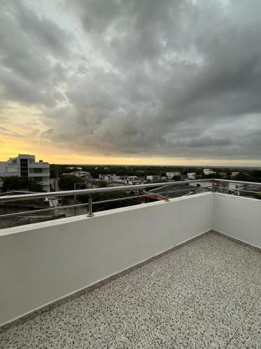 a white balcony with a view of a city at Lindo Apartamento suite country club villas in Santa Rosa