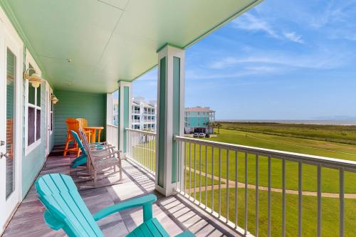 a balcony with two chairs and a view of the ocean at Sandpiper Point in Galveston