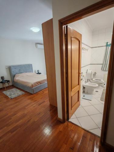 a bedroom with a bed and a bathroom at Casa Jugueiros in Viseu